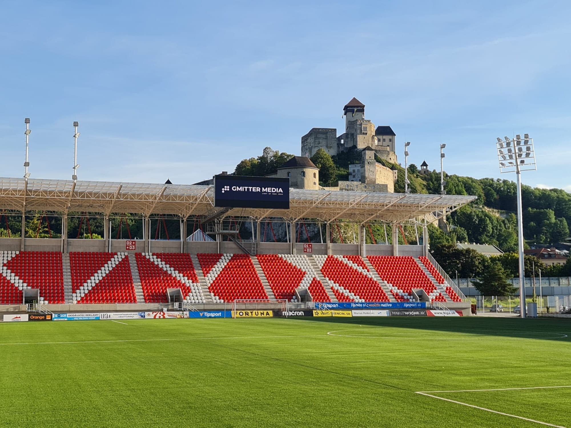 LED obrazovka GMITTER MEDIA nad tribúnou štadióna AS Trenčín, v pozadí Trenčiansky hrad