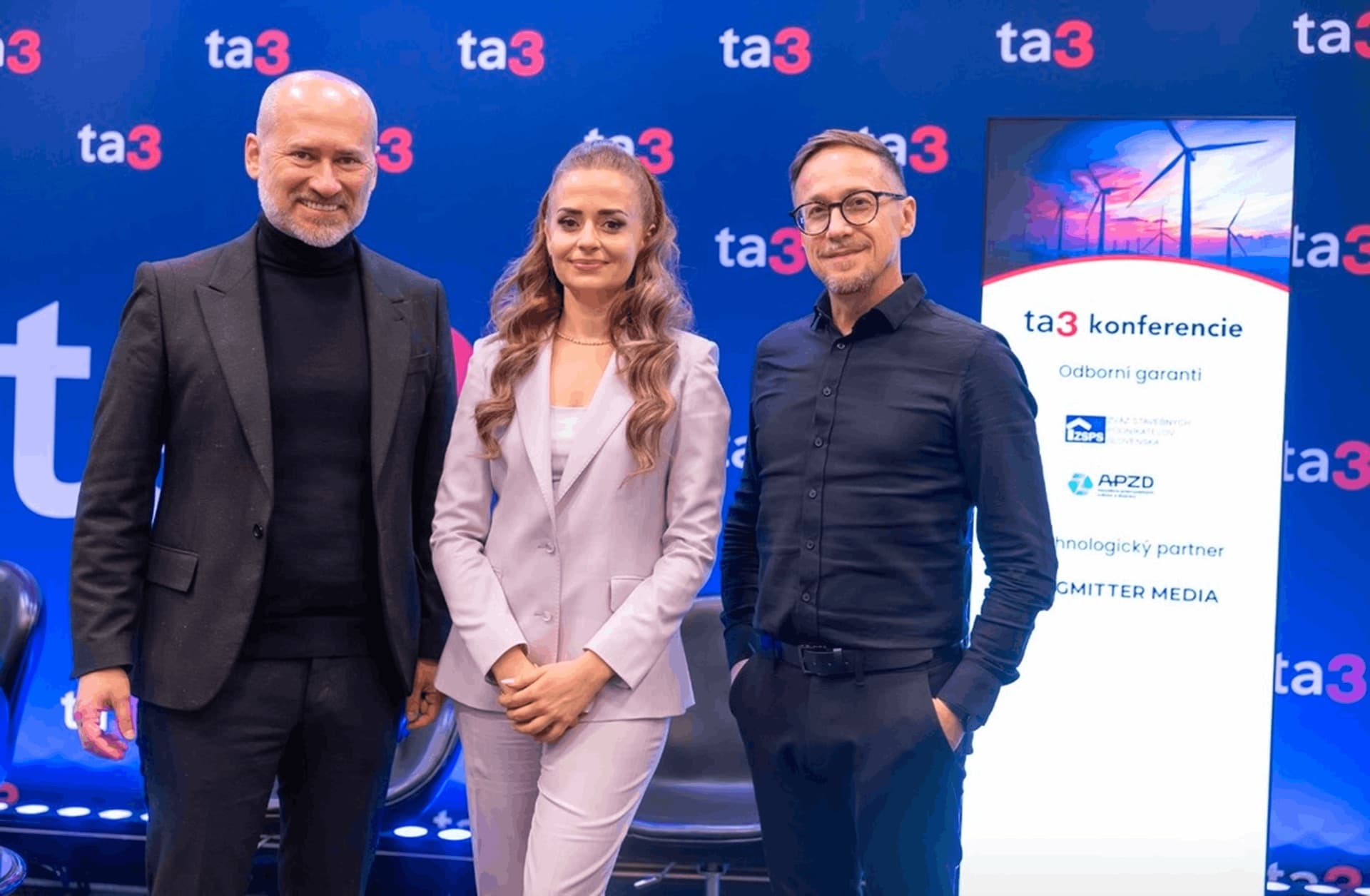 Rečníci pred LED video stenou s brandingom ta3 na konferencii